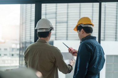 İnşaat alanında iletişim kurmak için telsizle iki mühendis kontrol ediyor..