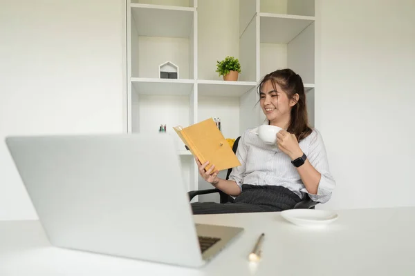 Piękna Młoda Azjatycka Bizneswoman Pije Kawę Trzyma Książkę Pracującą Laptopie — Zdjęcie stockowe