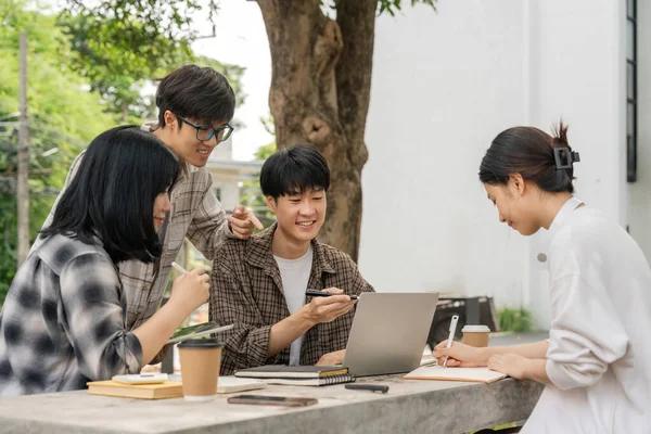 Grupa Młodych Szczęśliwych Studentów Azjatyckich Siedzących Stole Cementowym Patrzących Ekran — Zdjęcie stockowe