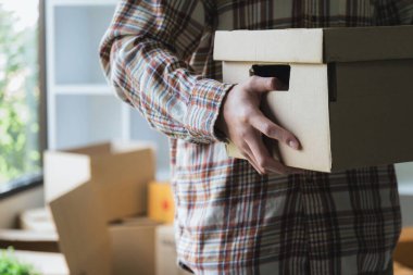 Close-up of a man with carton boxes moving into new home..