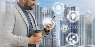 Hintli işadamı akıllı telefonuyla iletişim ağı arka planında sanal ikon diyagramı, dijital pazarlama, strateji ve iş analizi üzerinde çalışıyor.