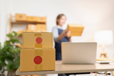 Kadın elleri karton kutu paketiyle memleketteki bir e-ticaret deposunda nakliye siparişi hazırlıyor. Çevrimiçi alışveriş teslimatı kavramı.