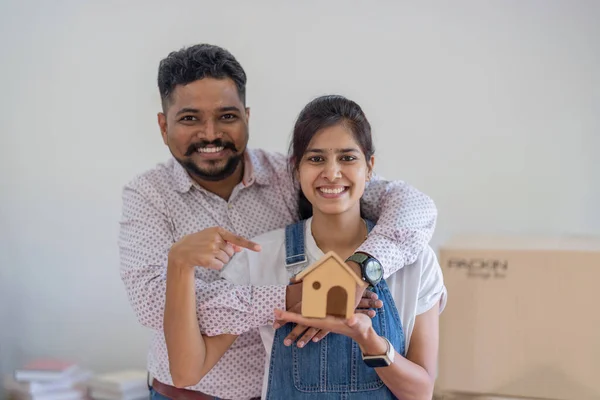 Indian couple is holding for a model home to choose a new home. relocation concept.