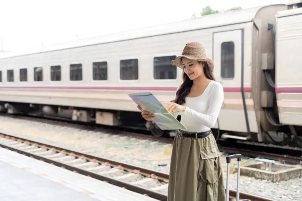 快乐的亚洲女性旅行者使用地图选择在火车站携带行李旅行的地方 暑假旅行的概念 — 图库照片
