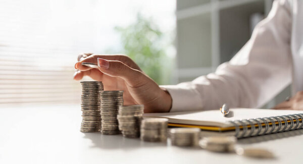 Young Asian woman making stack of coin. invest save finance concept, saving money, investment.