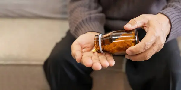 Medicine and healthcare of senior man taking daily pill for illness, medication and sick elderly with medical drugs, vitamin or supplements in his hand.