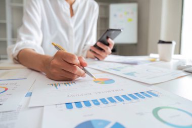 Asya işi, çalışma odasındaki mali rapordaki durumu analiz ediyor. Yatırım Danışmanı, Mali Danışman, Mali Danışman ve Muhasebe Konsepti.