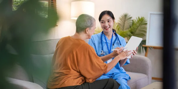 Asian female doctor who consult to patient explains health care symptoms and help elderly woman, Writing down diagnose and symptoms, elderly care, health care.
