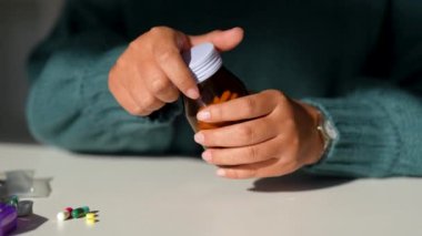 Kadınlar ilaç şişesindeki etiketi okuyup ev hayatı tarzında hap alıyorlar. Sağlık ve tıbbi konsept hastalıkları. Dişi bir hap alır ve bir bardak su içer..