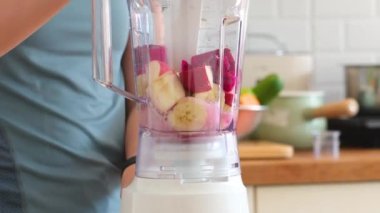 Sebze hazırlayan Asyalı kadın evde sağlık egzersizi yaptıktan sonra cilt ve sağlık için meyve harmanlanmış içecek hazırlıyor. diyet ve sağlıklı gıda konsepti.