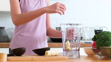 Sebze hazırlayan Asyalı kadın evde sağlık egzersizi yaptıktan sonra cilt ve sağlık için meyve harmanlanmış içecek hazırlıyor. diyet ve sağlıklı gıda konsepti.