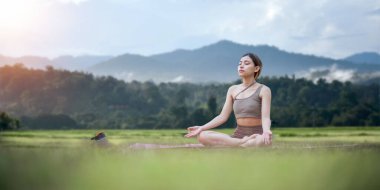 Spor paspasındaki Asyalı kadın, halka açık parkta yoga yapan sporcu kadın, vücudunu esnetiyor. Sağlıklı aktif yaşam biçimi.