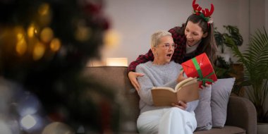 Kafkas Ailesi, kış tatili ve konsept mutlu anne-kız sürpriz Noel ağacı süsleme ve evde bir hediye.