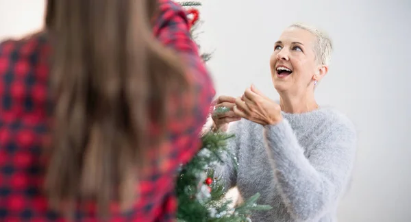 Gelukkig Senior Vrouw Met Volwassen Dochter Versieren Kerstboom Thuis — Stockfoto
