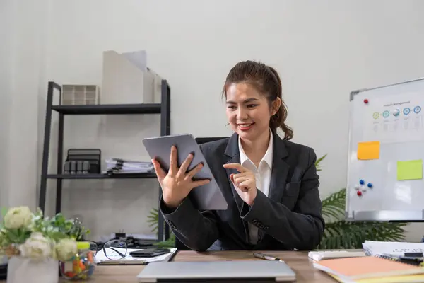 Young business woman executive worker holding digital tablet using pad technology device working standing in office.