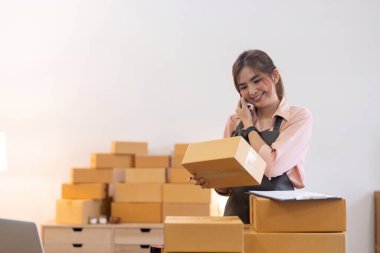 Asyalı girişimci kadın paket kutusunu hazırlayın ve online siparişleri kontrol edin. Online pazarlama, paketleme kutusu, KOBİ satıcısı. başlangıç iş konsepti.