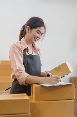 Asyalı girişimci kadın paket kutusunu hazırlayın ve online siparişleri kontrol edin. Online pazarlama, paketleme kutusu, KOBİ satıcısı. başlangıç iş konsepti.
