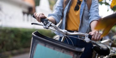 Şehir yolunda bisiklet süren Asyalı bir turist..