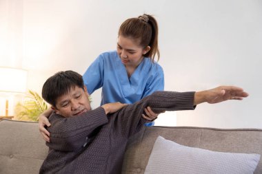 Kadın doktor ya da bakıcı, erkek yaşlılara sağlık evinde fizik tedavi uyguluyor. Destek ve iyileşme sürecinde. uzman fizik tedavi.