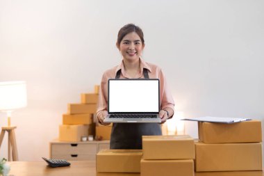 Küçük işletme girişimcisi KME, evde kutu ile çalışıyor, Online satış, ekommerce. Kutulu boş dizüstü bilgisayarın bir kopyası. Çevrimiçi iş kavramı.