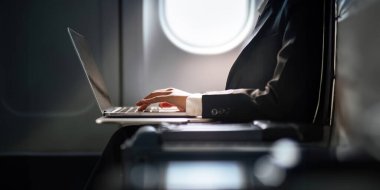 Başarılı Asyalı iş kadını, uçuş sırasında laptopta çalışan iş kadını..