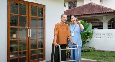 Hemşire ya da bakıcı ve yaşlı kadın desteği, sağlık hizmetleri ve evde sağlık portresi. Tıbbi fizyoterapi, doktor evde engelli yaşlı hastalara yardım ediyor..