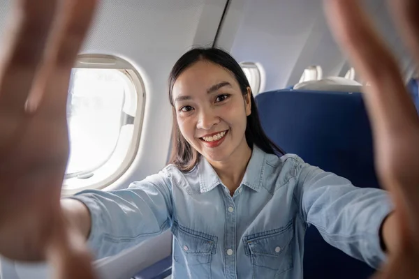 旅行和技术 年轻的亚洲女人坐在飞机座位上自私自利 — 图库照片