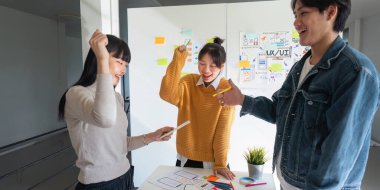 Ux geliştiricisi ve Ui tasarımcısı akıllı gündelik kıyafetlerde başarılı olup telefon uygulaması tasarımını tartışırken ofiste mutlu olduktan sonra beş yıl kutladılar..