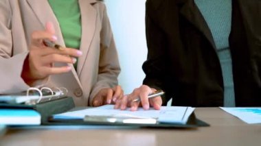 İş kadını dizüstü bilgisayar kullanırken sekreterin ofiste imza atması için belge vermesi, müdürün defter üzerinde çalışması, iş kadınının da imza vermesi, iş konsepti.