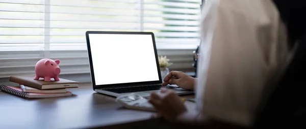 Laptop screen mock up, laptop in blank empty screen on the desk in home while woman working on financial calculating.