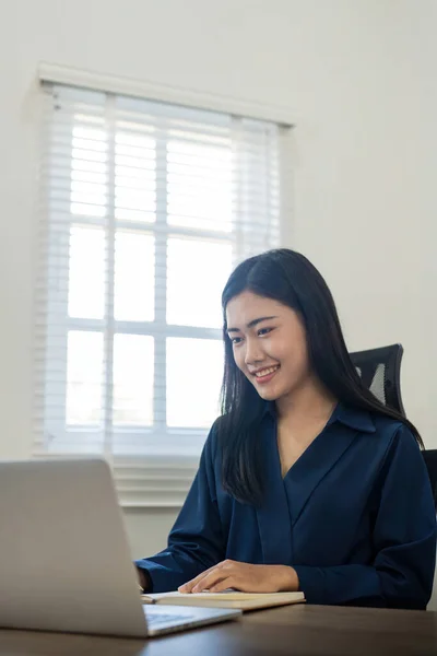 ハッピー 若い女性 アジア ノートを取るラップトップの家の距離から働く 笑顔のビジネス女性 コンピュータを使用して ウェビナーを見る ノートブックに机の上に座って — ストック写真