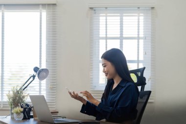 Genç Asyalı iş kadını iş prensiplerini hesaplamak için hesap makinesi kullanıyor. Ofiste muhasebe istatistikleri kavramı.