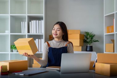 Kadınlar paketleme, nakliyat, çevrimiçi satış, internet pazarlama ekommerce konsepti girişimi fikrine ürün hazırlamak için koli bandı kullanırlar..