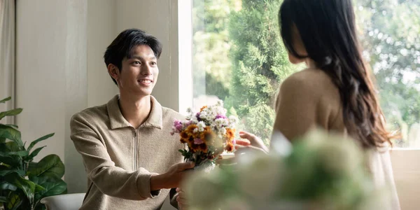 Romantic Young Asian Couple Embracing Holding Flowers Smiling Living Room — Stock Photo, Image
