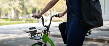 Bisikletli Asyalı iş kadını ofiste işe gider. Bisikletli seyahat, çevreci taşımacılığı kullanan mutlu bir iş kadını, ekolojik yaşam tarzı kavramı..