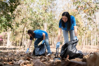 Ormanda plastik çöp toplayan bir gönüllü. Çevre koruma kavramı. Küresel çevre kirliliği. Ormanı temizliyorum..