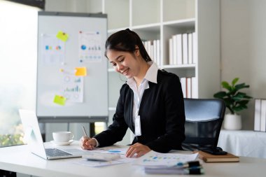 İş kadını muhasebeci ofis odası, iş finans, vergi, muhasebe kavramında mali veri tasarrufu için hesap makinesi ve dizüstü bilgisayar kullanıyor..