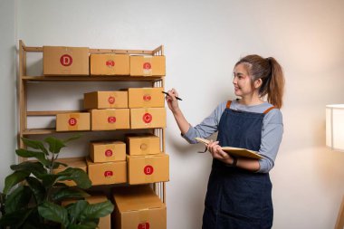 Girişim KOBİ küçük işletme girişimcisi KME ya da kutulu laptop kullanan serbest çalışan Asyalı kadın, genç başarılı Asyalı kadın çevrimiçi pazarlama paketleme kutusu ve teslimat konsepti.