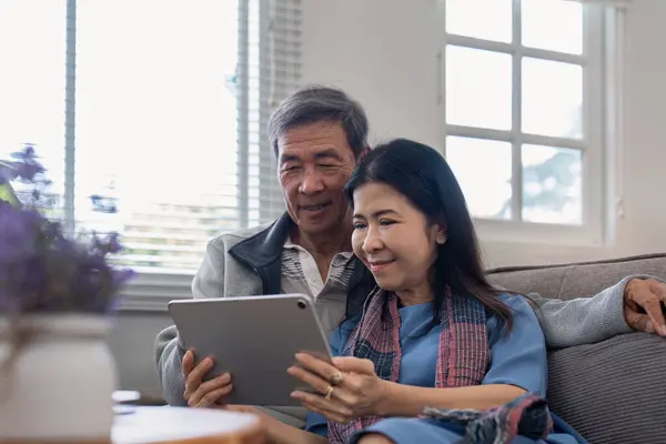 Glückliche Ältere Asiatische Paare Mit Tablet Sitzen Auf Dem Sofa — Stockfoto