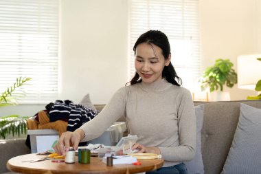 Dikiş diken kadın, eski giysilerin kumaşlarını ekonomik olarak yeniden kullanıyor. DIY Hobisi Yeniden Kullanım Geri Dönüşümü.