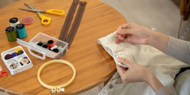 Dikiş diken kadın, eski giysilerin kumaşlarını ekonomik olarak yeniden kullanıyor. DIY Hobisi Yeniden Kullanım Geri Dönüşümü.