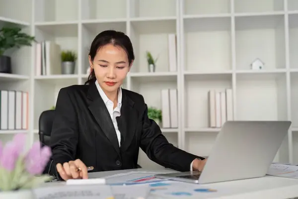 年轻的亚洲商业女性或员工会计簿记文档检查财务数据或销售报告与笔记本电脑在办公室工作 纸本管理 — 图库照片