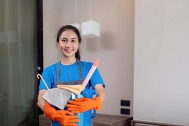 Temizlik ürünleri, ve evde bakterileri temizlemek için yatak odasında Asyalı kadın temizlik sepetleri. Oda temizleyici ya da konteynırlı hizmetçi..