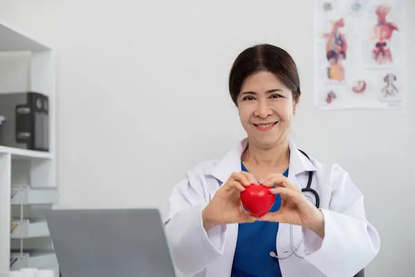 Gelukkige Jonge Dokter Senior Vrouw Met Rode Hartvorm Object Kijken — Stockfoto