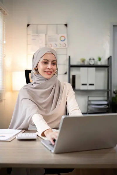 stock image Asian Muslim businesswoman in hijab head scarf working with paper document in the modern office. diversity and office concept.