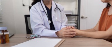 Doktor, sağlığınızı kontrol ederken hastaların elini tutuyor ve cesaretlendiriyor..