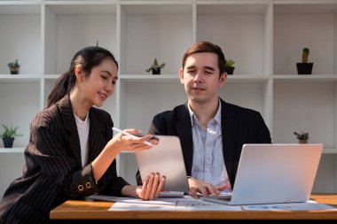 Çeşitli ortaklardan oluşan takım işleri. İş kadını, dizüstü bilgisayar ve tablet üzerinde proje tartışıyor. Profesyonel iş adamlarının iki meslektaşı birlikte çalışıyor..