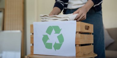 Tekrar kullanılmak üzere kullanılmış giysilerle dolu bir kadın çantası. Yeniden kullanım, geri dönüşüm materyali ve moda atıklarının azaltılması, ikinci el giyim fikri. Dairesel moda, sıfır atık kavramı.