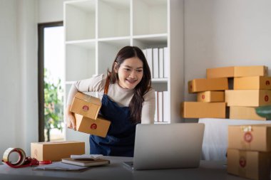 Girişim KOBİ küçük işletme girişimcisi KME ya da kutulu laptop kullanan serbest çalışan Asyalı kadın, genç başarılı Asyalı kadın çevrimiçi pazarlama paketleme kutusu ve teslimat konsepti.