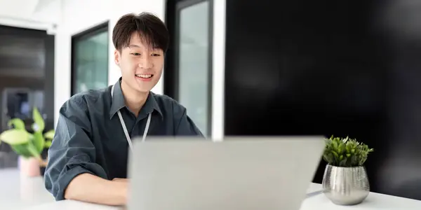 stock image Businessman using laptop computer in office, Happy young asian businessman in modern office looking on laptop.